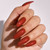 Almond-shaped nails wearing Volcano by The GelBottle Inc., a rich red gel polish with subtle shimmer and a glossy finish.