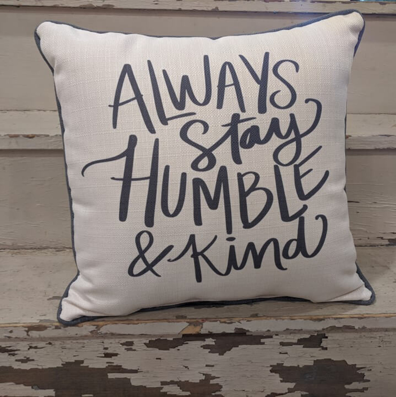 The perfect way to cozy up any space! "ALWLAYS Stay HUMBLE & Kind" sentiment is dyed directly into the fabric, so it won't peel or crack; grey piping around the edge for an extra pop! Made from a soft yet durable polyester fabric, your pillow will arrive stuffed with poly-fill and sewn shut.  Approx. 17" square; machine washable in cold water, delicate cycle- fluff, air dry flat.