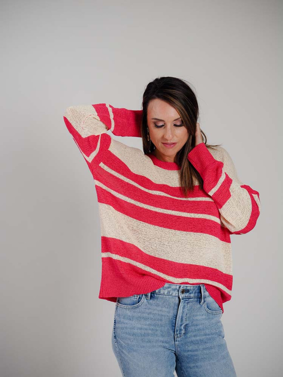 Light weight loose knit natural beige colored sweater with bright pink stripes. Bright pink at the wide round neck, long sleeves