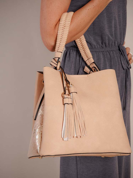 Soft apricot colored vegan leather bag features a metallic snake print on the side, rose gold hardware, and removable dual decorative tassels. Braided handle and an adjustable/removable crossbody strap. This bag has three large pockets- outside pockets close with magnet snaps and middle pocket has zipper close. Middle pocket also has a small lined zipper pocket and a lined slip pocket. Soft apricot colored vegan leather bag features a metallic snake print on the side, rose gold hardware, and removable dual decorative tassels. Braided handle and an adjustable/removable crossbody strap. This bag has three large pockets- outside pockets close with magnet snaps and middle pocket has zipper close. Middle pocket also has a small lined zipper pocket and a lined slip pocket.