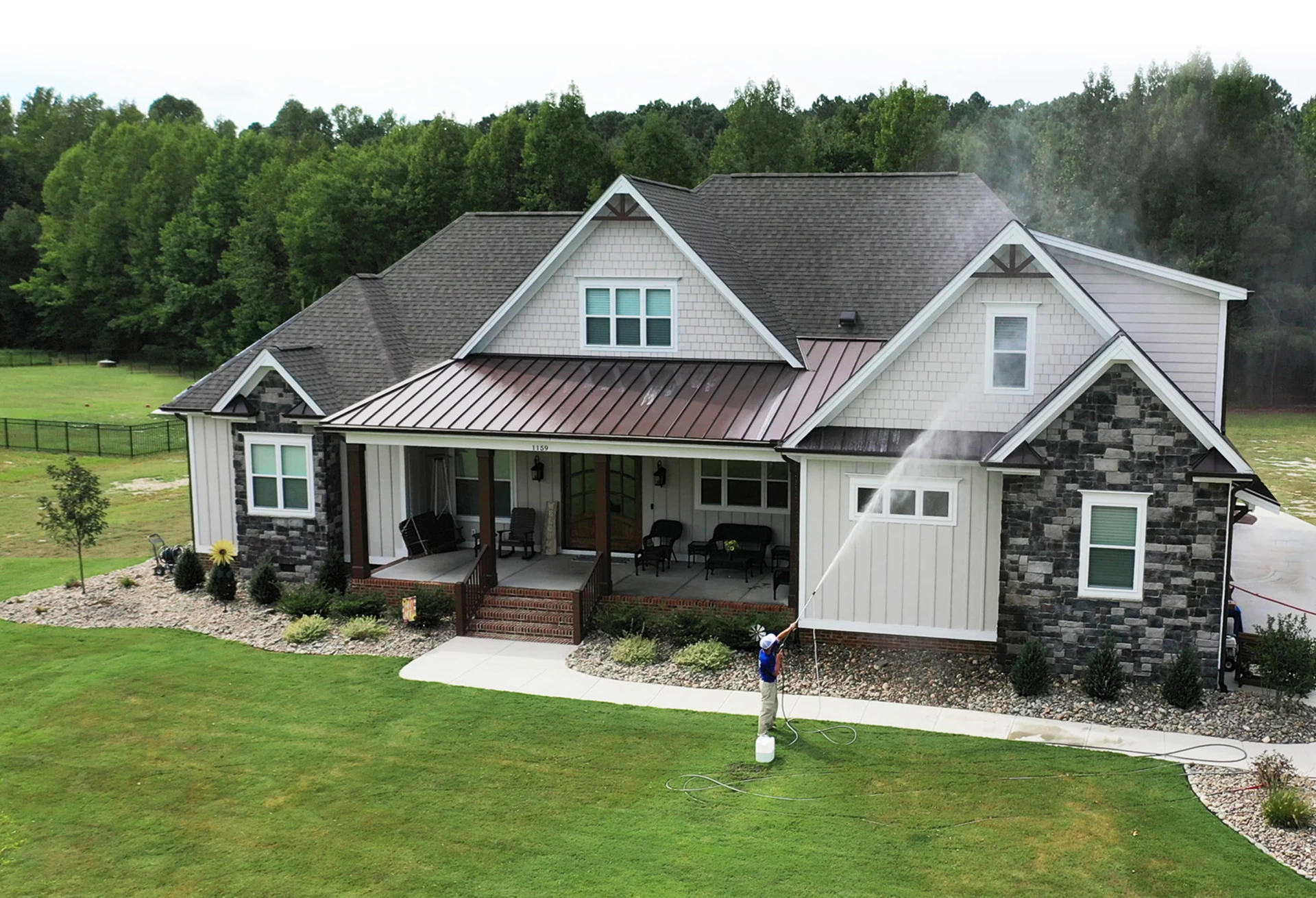 Contractor cleaning a house exterior from the ground using the X-Jet M5