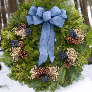 Blueberry Fresh Christmas Wreath with Blue Linen Bow
A beautifully handcrafted Blueberry Fresh Christmas Wreath, made with fresh balsam fir, pine, and cedar. Decorated with life-like blueberries, real pine cones, and white German statice, this wreath is topped with a hand-tied blue linen bow for an elegant holiday look.