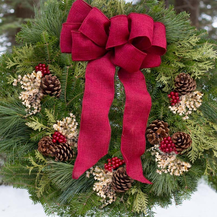 Fresh Winterberry Christmas Wreath made with mix of balsam, cedar, and white pine. Decorated with pine cones, white german statice, faux red berries, and topped with a beautiful cranberry linen bow.