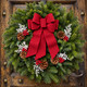 Winterberry fresh balsam wreath with cranberry bow, pinecones, red berries and white statice on a rustic wood door