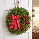 Cape Elizabeth fresh balsam wreath with cranberry linen bow, pinecones and red berries on a white front door