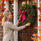 Woman hanging wreath on front door