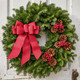 Cape Elizabeth fresh Maine balsam Christmas wreath with cranberry linen bow, pinecones and red berries on a white wooden door