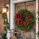 Buffalo Plaid fresh balsam Christmas wreath hanging on a rustic wooden front door decorated for Christmas