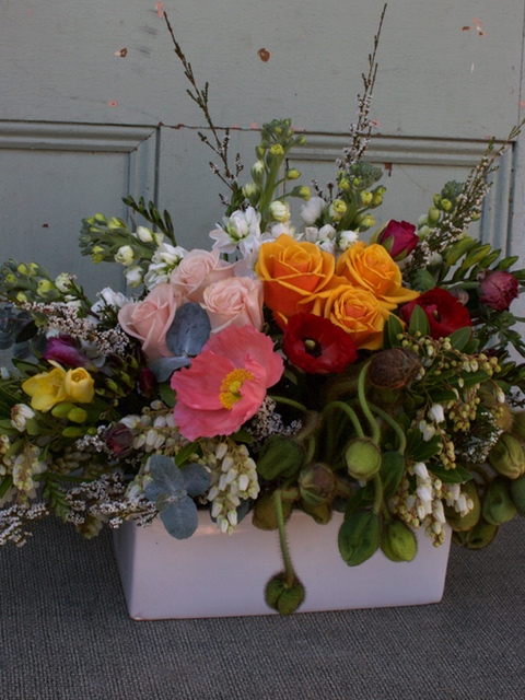 Flowers arranged into white ceramic in a vibrant colour palette