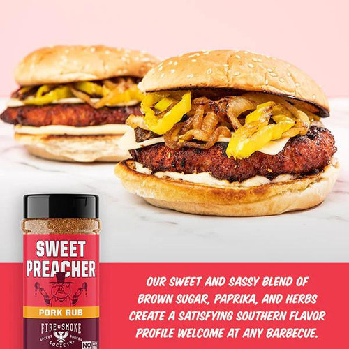 Fire & Smoke Society F&S - Ultimate BBQ Bundle, close-up of two BBQ sandwiches with grilled meat, pickles, and condiments in sesame seed buns.