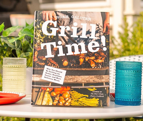 Grill Time! Cookbook, a hardcover cookbook with a cover image of outdoor grilling and food, displayed on a table with colorful glasses and a garden setting.