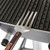 GrillGrate® for PK360, stainless steel grilling grate with slotted design on a portable grill.