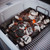 Charcoal basket with lit briquettes demonstrating improved airflow control and precise heat management.