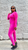 Black female model with sleek black bob wearing MTAP buttery soft hot pink long sleeve top and matching high-waisted leggings with white sneakers against a pink background.