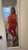 Woman wearing an orange MTAP rhinestone zip-up hoodie with matching high-waisted leggings.