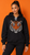 Mixed-race model with a high ponytail wearing a black lace-up hoodie with an orange, black, silver, and pink rhinestone tiger face against an orange wall.
