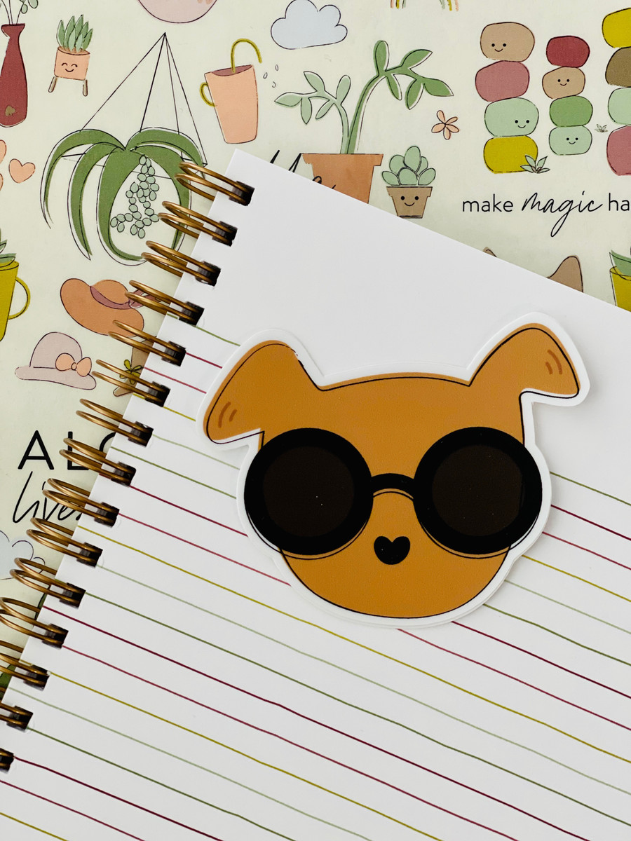 adhesive sticker in the shape of a brown dog with sunglasses on