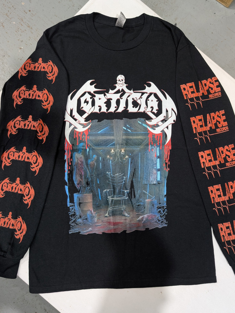 Mortician 'Hacked Up for Barbecue' (Black) Long Sleeve Shirt laid out on a bench