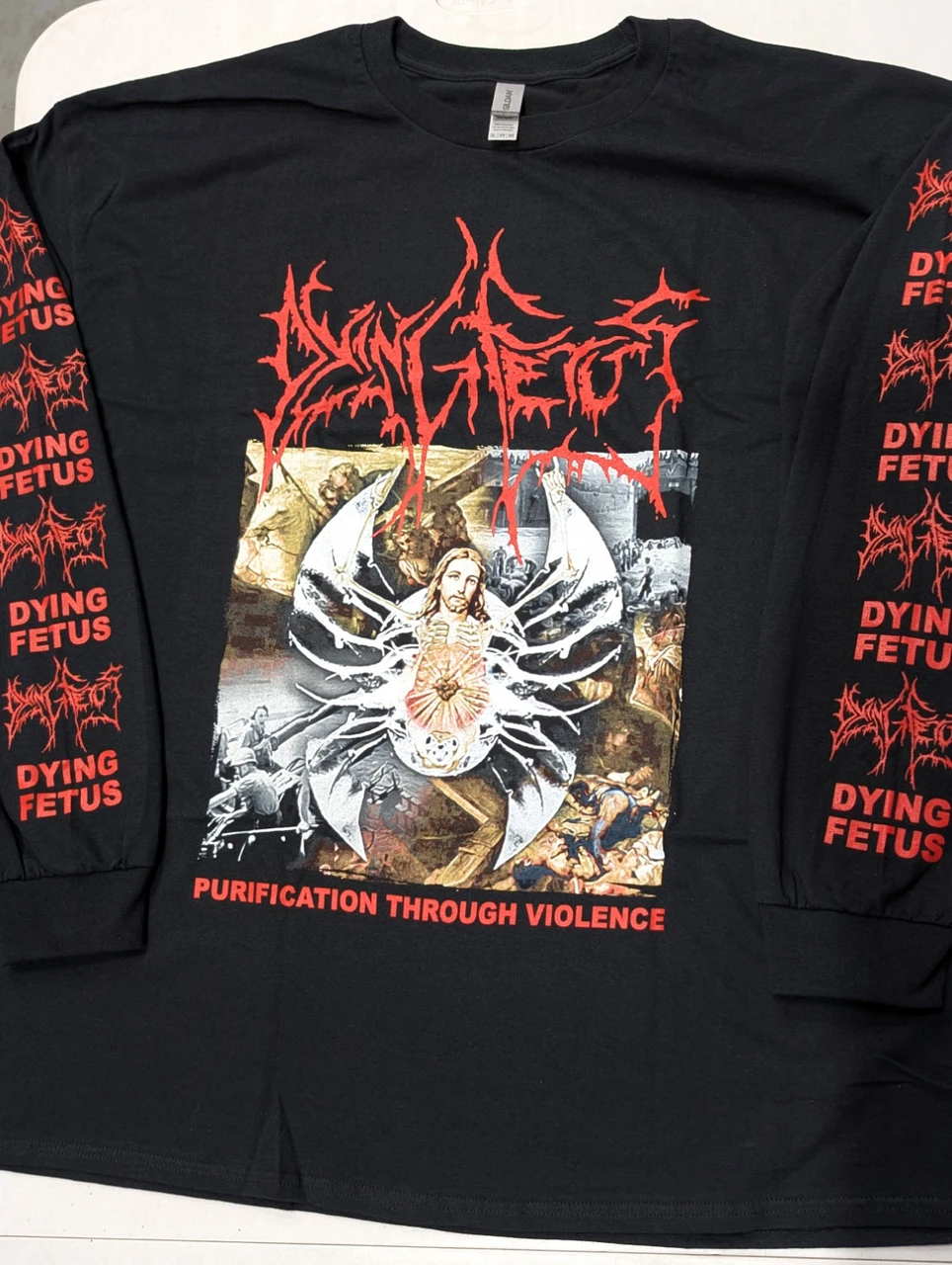 Dying Fetus 'Purification Through Violence' (Black) Long Sleeve Shirt laid out on a bench