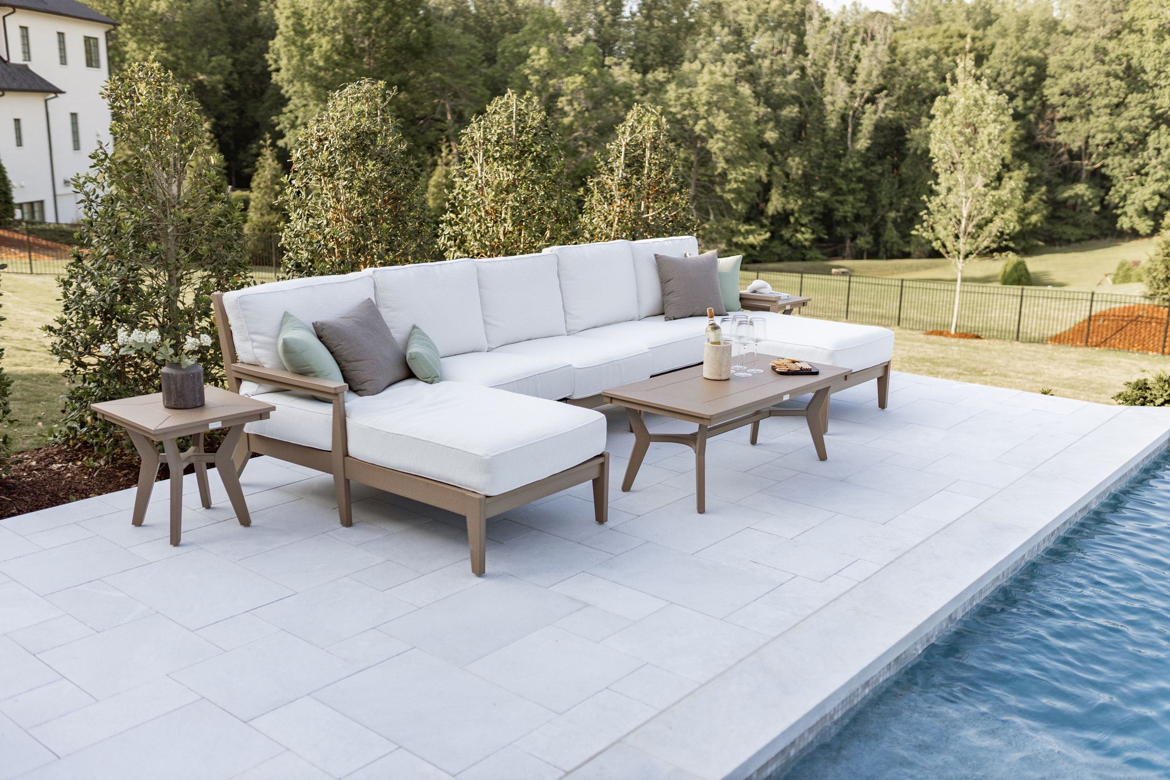 Weather-resistant poly deep seating sectional with Sunbrella cushions in a backyard setting