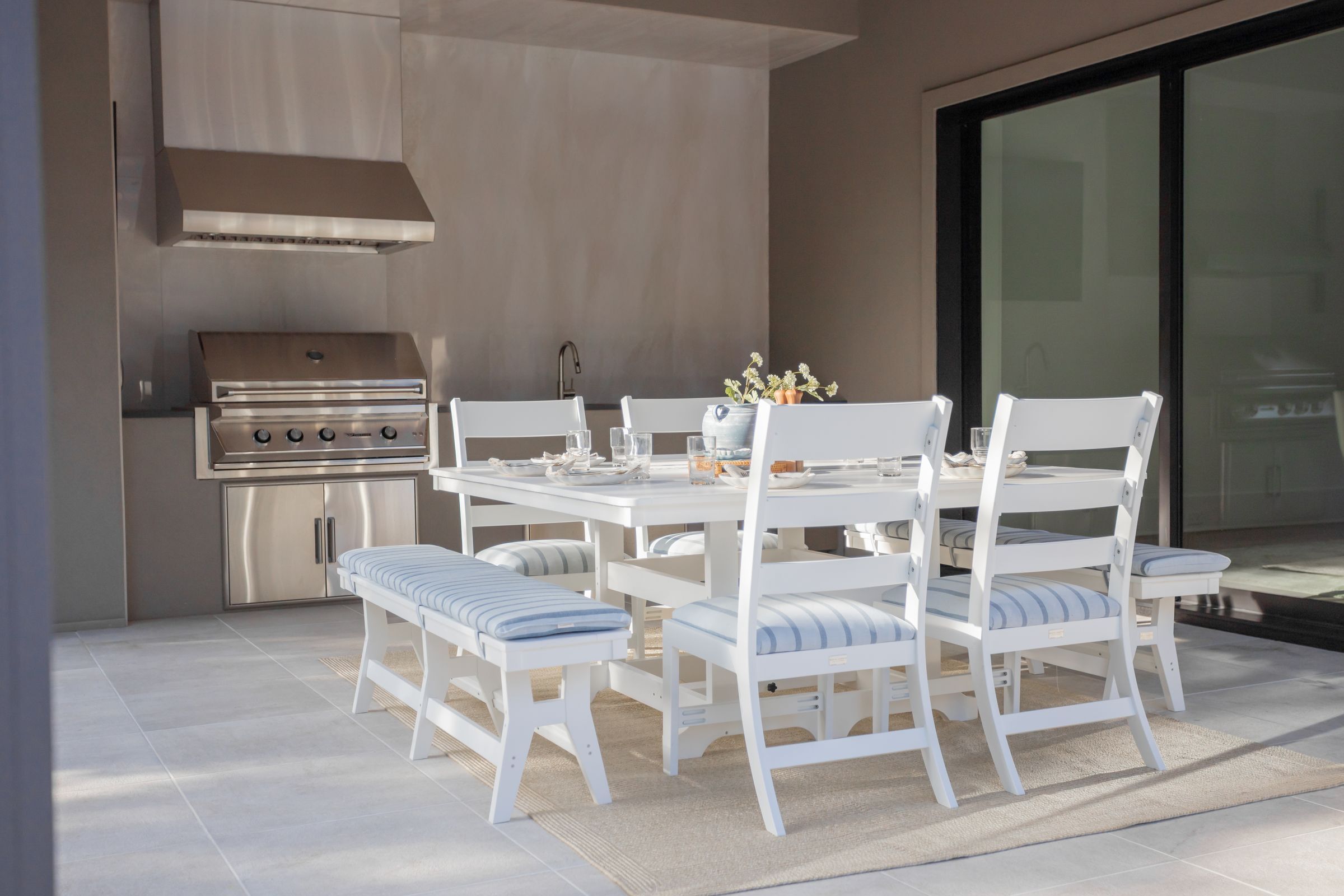 Rectangular outdoor poly dining table with coastal style sunbrella sling seating