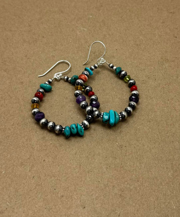 Handcrafted Navajo pearl hoop earrings featuring sterling silver beads, turquoise nuggets, coral, amethyst, and multi-colored gemstone accents, arranged in a circular design with silver French hook ear wire. Handcrafted Navajo pearl hoop earrings featuring sterling silver beads, turquoise nuggets, coral, amethyst, and multi-colored gemstone accents, arranged in a circular design with silver French hook ear wire.