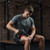 Man using Novaa Pulse red light massage gun on thigh for targeted muscle recovery and soreness support.
