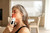 Woman using a handheld red light therapy device on her face and neck for targeted skincare and recovery support
