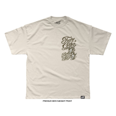 Natural cream premium heavyweight tee, front. Airbrushed left-chest design reading "Tracy Cortez / Born For This" in sepia-toned script with two cherub angels. Born For This™ neck logo and side label.