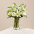 Delicately arranged in an 8" vase, this all white bouquet includes snap dragon, lilies roses, and greenery. 