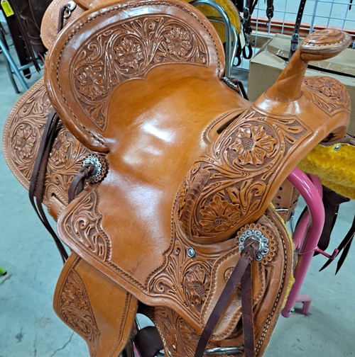 New Stock Saddle in Hermann Oak leather by Fort Worth Saddle Co with 13 inch seat. Light oil slick seat with all floral tooling and floral embellished pencil roll cantle. Gullet size is 7 inch, weight is 27lbs, and skirt is 25 inch. Made in USA. Limited lifetime warranty.

S978