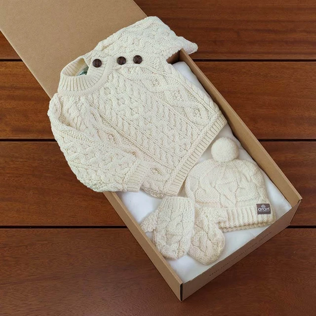 My First Aran Baby Gift Set with hand-knitted cream cable-knit sweater, pom-pom hat, and matching mittens—crafted from soft merino wool and beautifully boxed for newborn gifting, christenings, or baby showers.