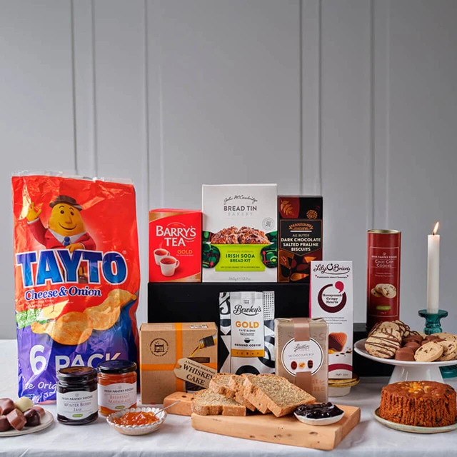 Across The Miles Hamper featuring Tayto cheese and onion crisps, Barry’s Tea, Bewley’s coffee, Irish soda bread mix, Christmas pudding, gourmet chocolates, cookies, and festive treats – available at GiftsDirect.com