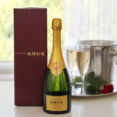 Krug Grand Cuvée Champagne in maroon gift box – premium bottle with gold foil neck, elegant label, accompanied by champagne flutes, ice bucket, and red rose for a luxurious presentation.