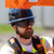Worker wearing Malta Dynamics APEX safety goggles under a hard hat on a jobsite