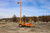 Malta X1000E mobile grabber deployed on a jobsite with the mast raised to an overhead anchor point