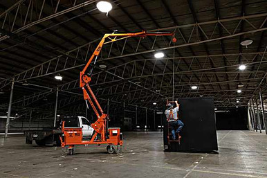 Malta Dynamics X1200 Mobile Grabber Facility Electric Overhead Anchor Malta X1200 facility mobile grabber deployed inside a warehouse with a worker tied off to the overhead anchor point