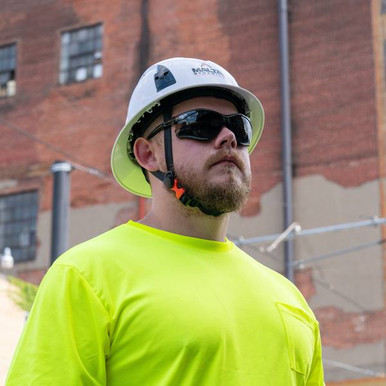 Worker wearing Malta Dynamics APEX foam lined safety glasses with a hard hat on a jobsite