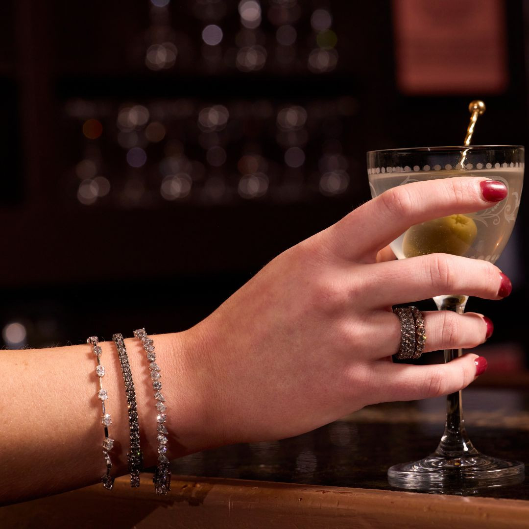 On figure view of oval, pear & round multi shape diamond tennis bracelet.