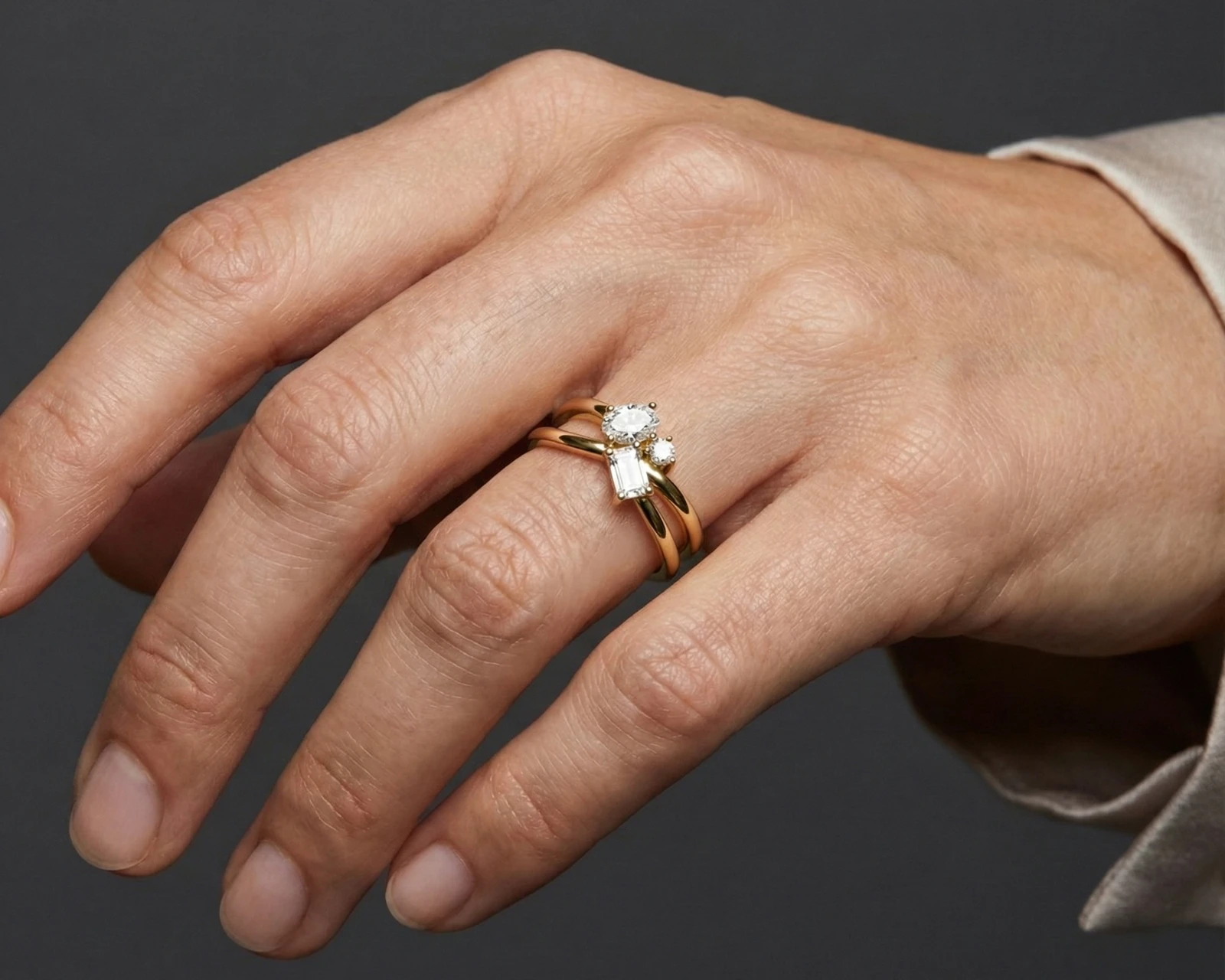 A top-down view of a 14K white gold bypass ring with a central cluster of three horizontal baguette diamonds on hand.