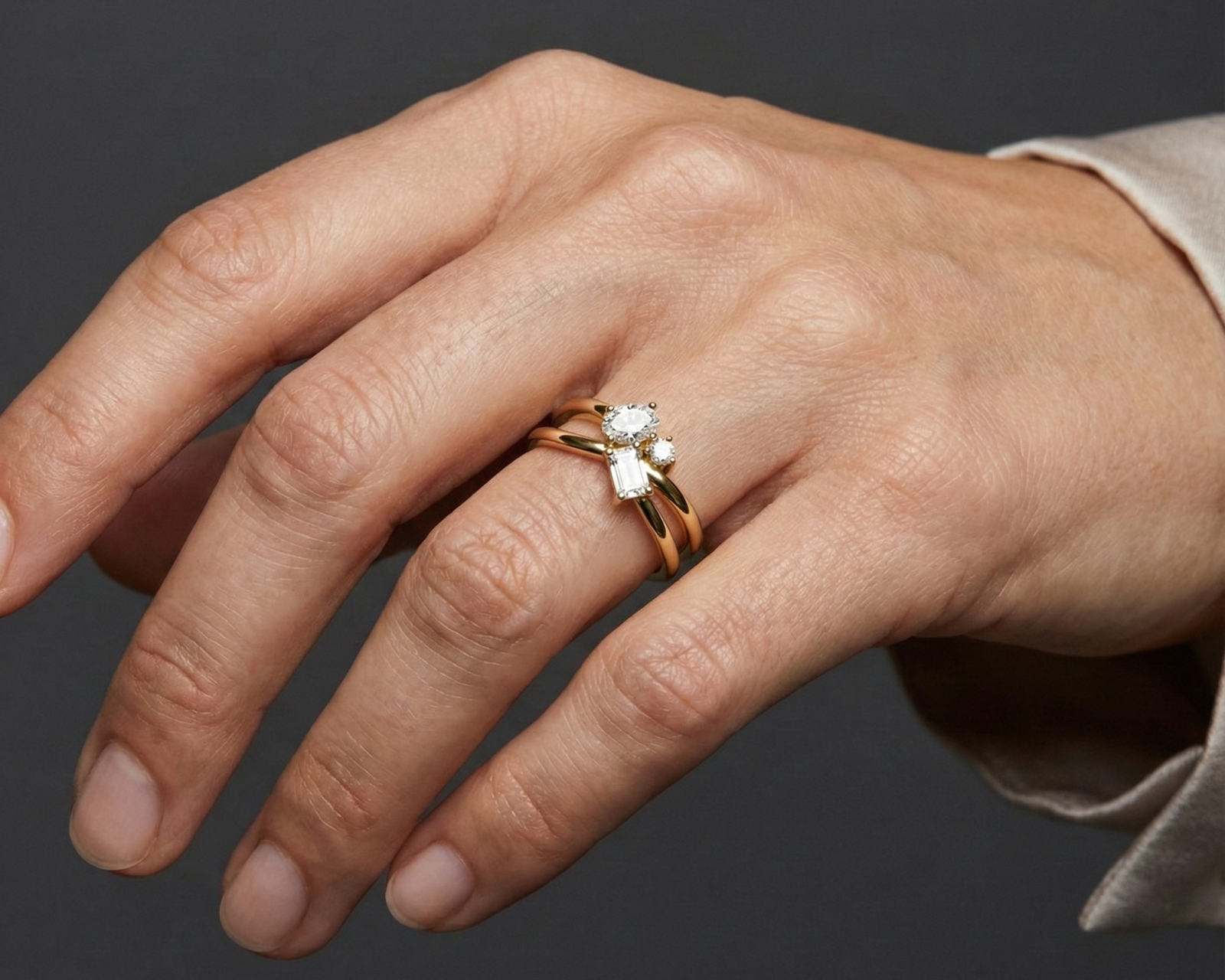 A top-down view of a 14K white gold bypass ring with a central cluster of three horizontal baguette diamonds on hand.