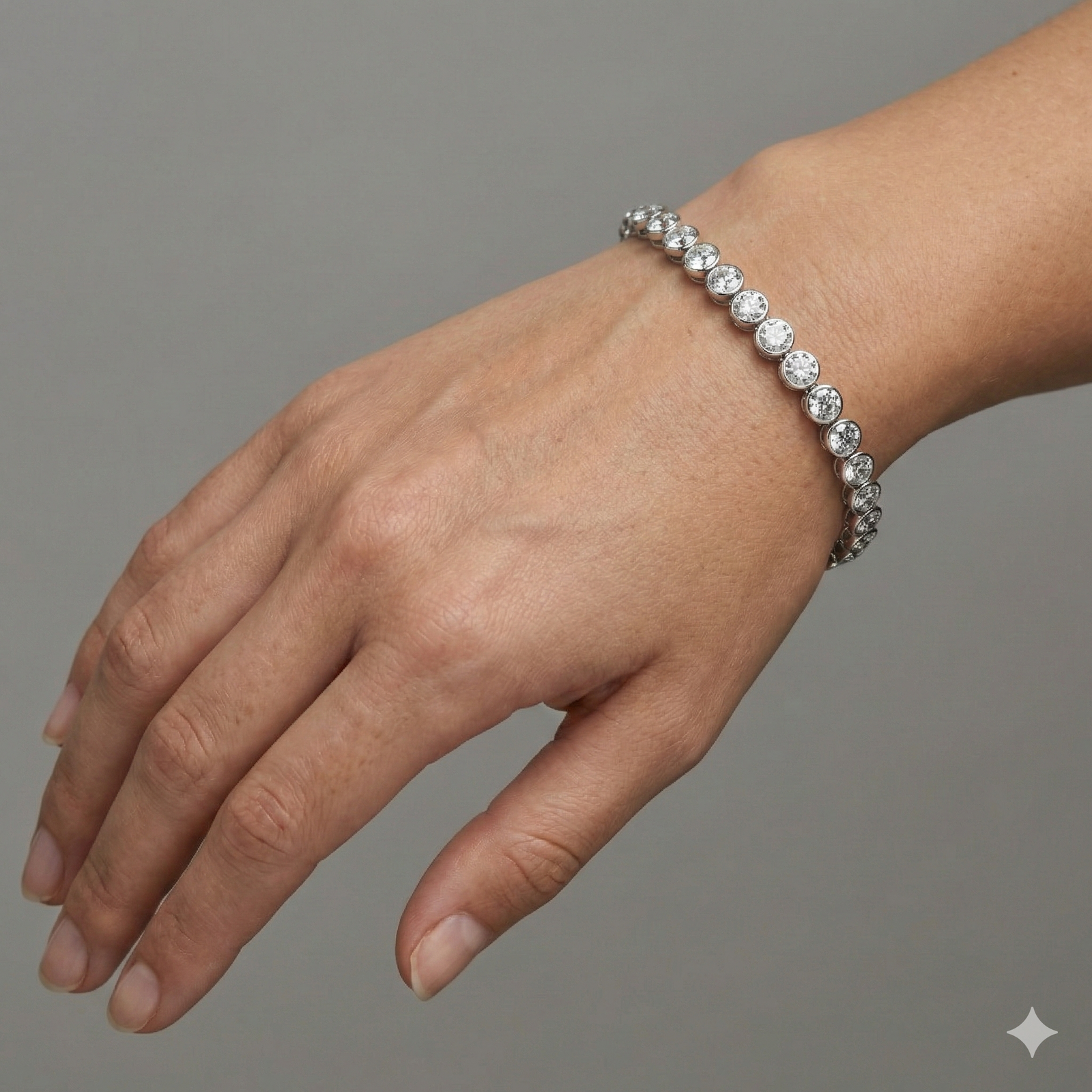 A full top-down view of a 14K white gold tennis bracelet, coiled to show the seamless circle of brilliant diamonds on wrist.