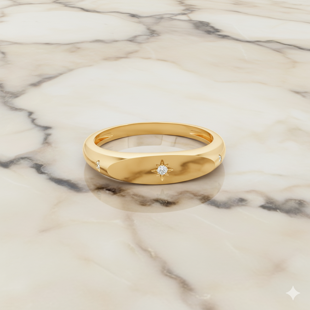A top-down view of a 14K yellow gold signet ring with a round jewel and a sunburst motif on a marble background.