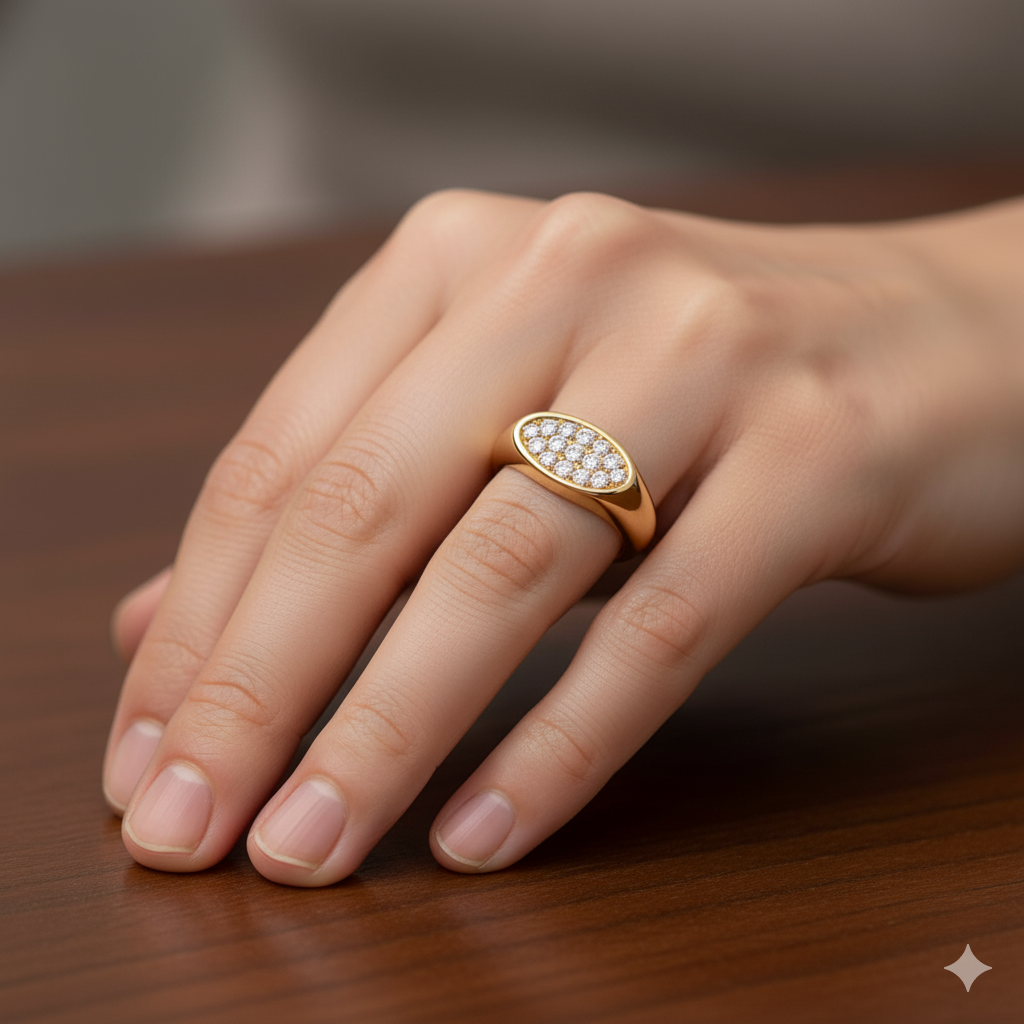An angled view of a 14K yellow gold signet ring, showcasing the continuous sparkle of the oval, pavé-set diamonds on a hand.
