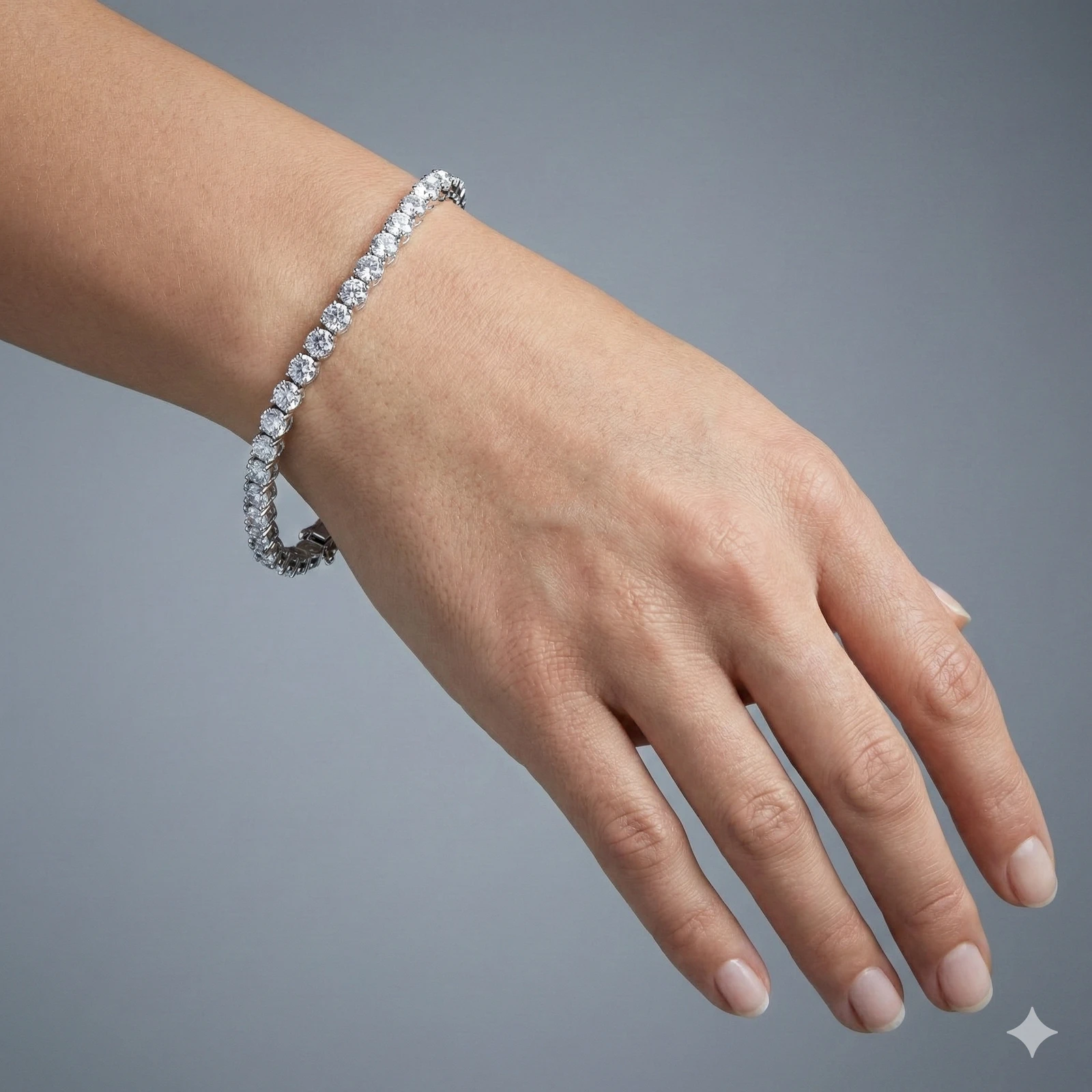 An angled view of the 14K white gold F VS diamond tennis bracelet, showing the gold cup setting and secure clasp on wrist.