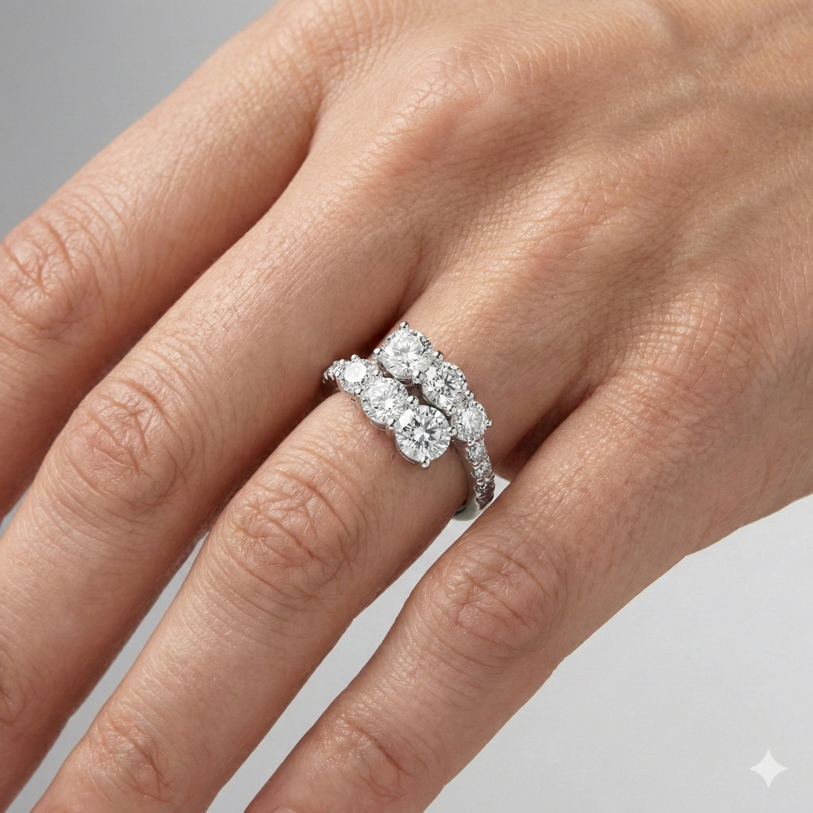 Yellow gold diamond ring resting on black marble, featuring multiple round brilliant-cut diamonds arranged in a modern layered design with pavé diamonds on hand.