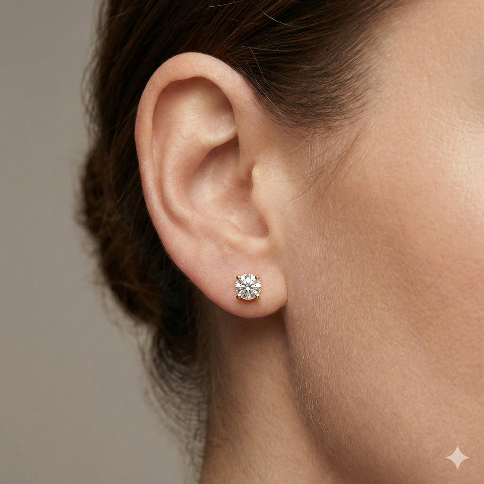 Front view of white gold round solitaire diamond stud earrings featuring brilliant-cut diamonds secured in a classic four-prong setting on ear.