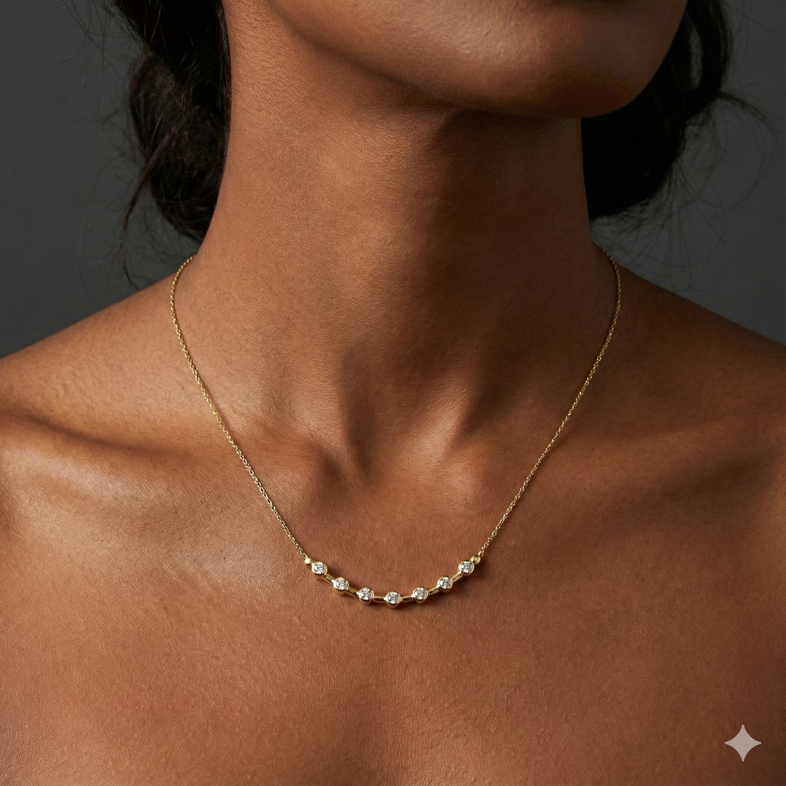 Angled wide view of a yellow gold diamond station necklace resting on a black marble surface, highlighting the contrast between white diamonds and warm gold.
