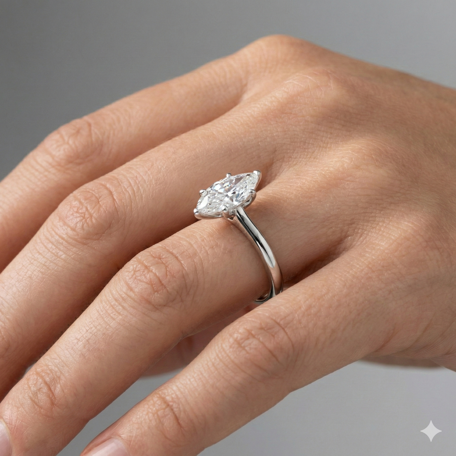 Marquise cut diamond engagement ring in 14k white gold with a plain band and solitaire setting on a hand