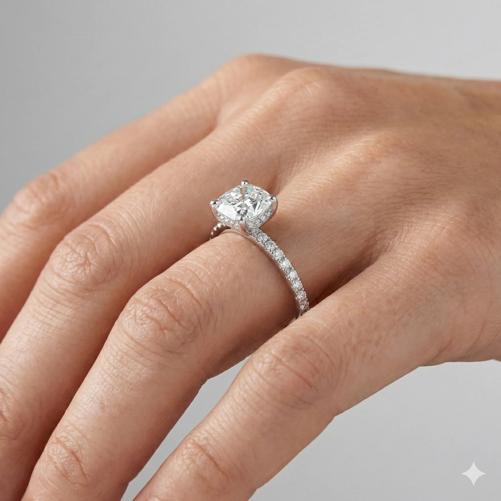 Elongated cushion cut diamond engagement ring in 14k white gold with a prong diamond band and cathedral setting on a hand